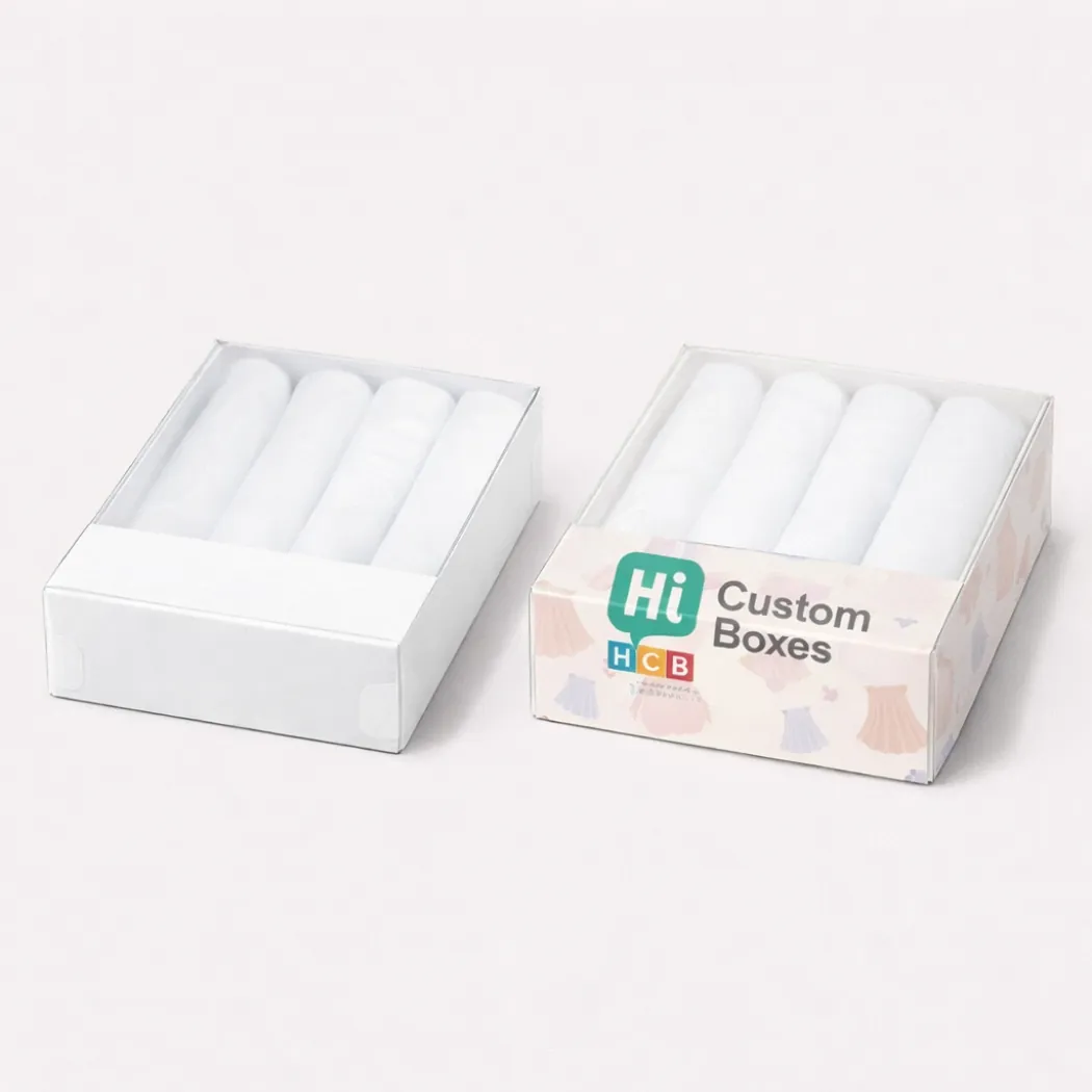 Two flat rectangular boxes with clear lids- each containing four neatly rolled white garments for display- class=